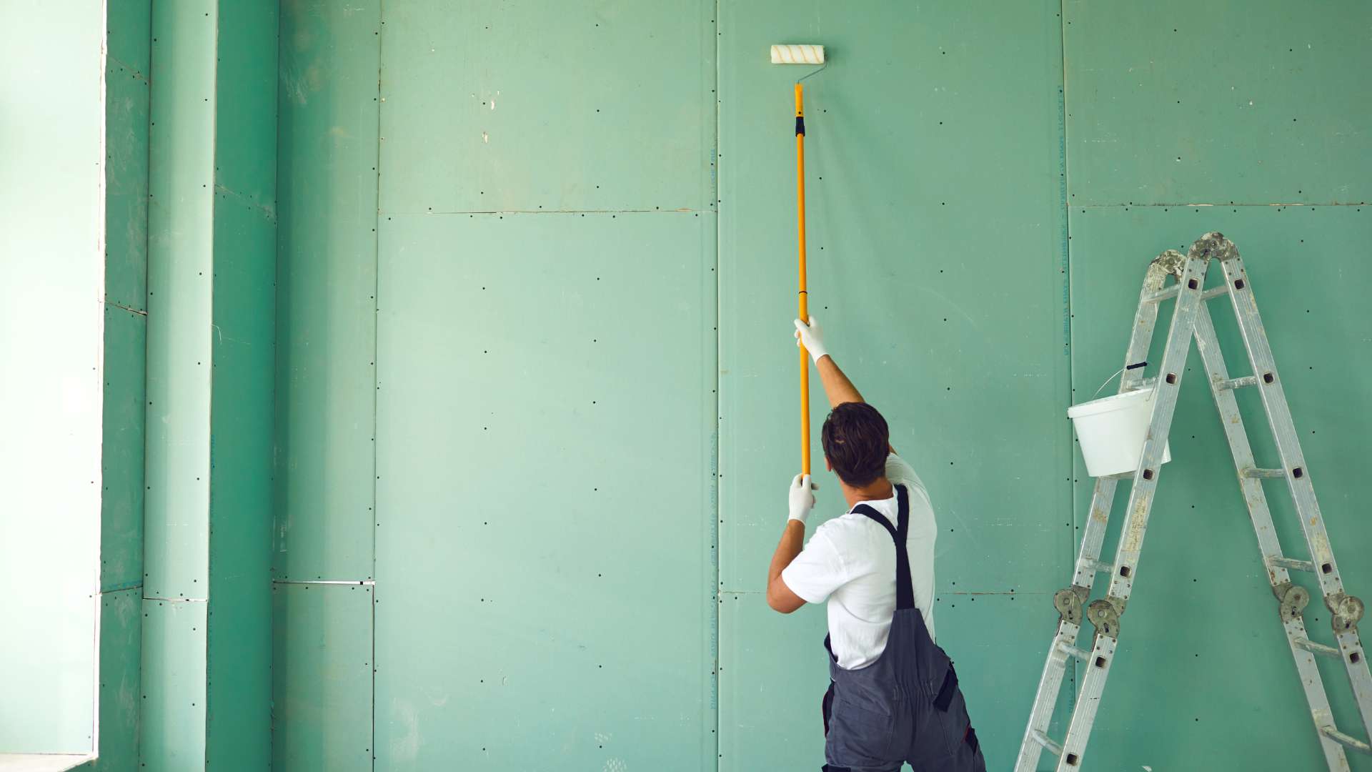 Professional painter applying a commercial interior wall coating